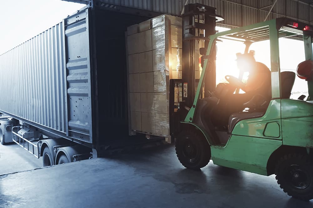 A forklift driver sitting in a forklift in a warehouse