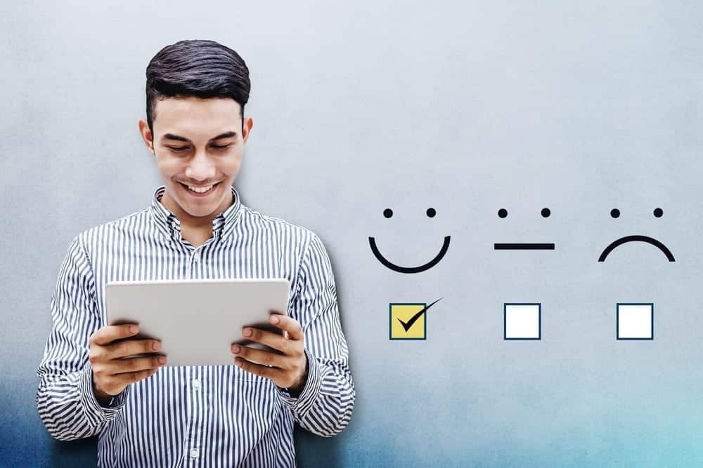 A man holding a tablet smiling.