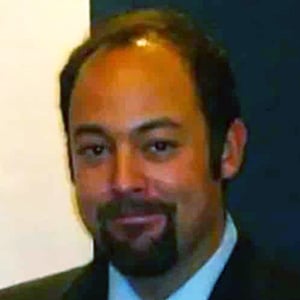 A dark haired man smiling