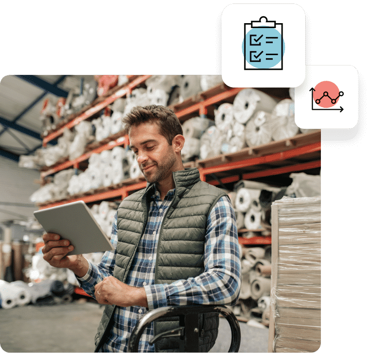 A man in a warehouse smiling and holding an ipad