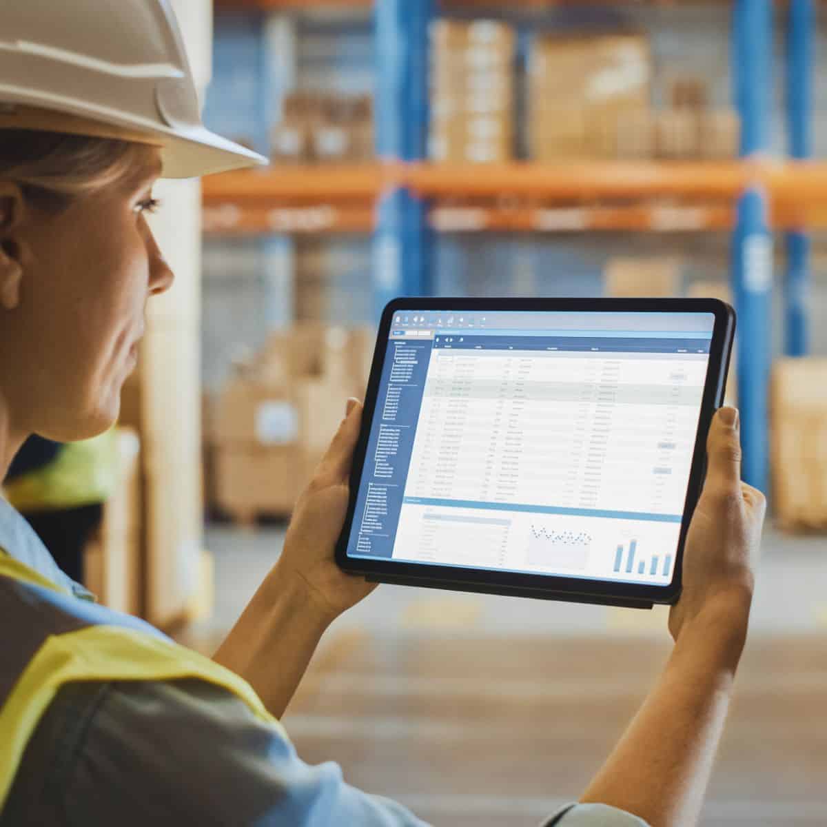 Woman in a warehouse holding a tablet.