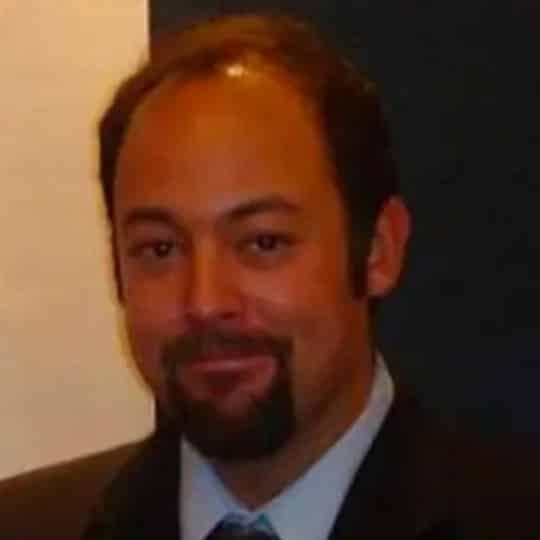 A dark haired man smiling