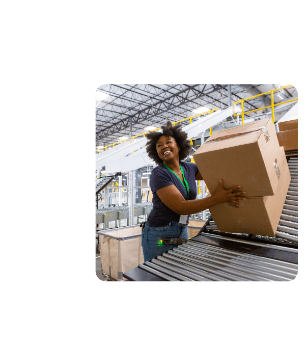 Warehouse Employee Smiles As She Takes Package Off of Conveyor Belt