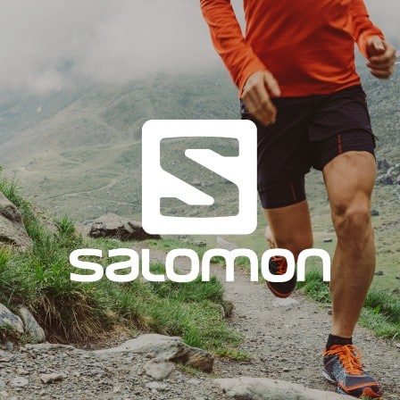 Man running on a trail wearing Salomon sneakers.