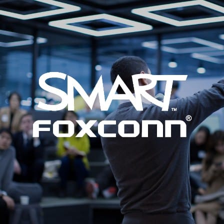 A man standing in front of an audience with the FoxConn logo