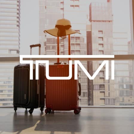 Luggage in a hallway with the Tumi logo