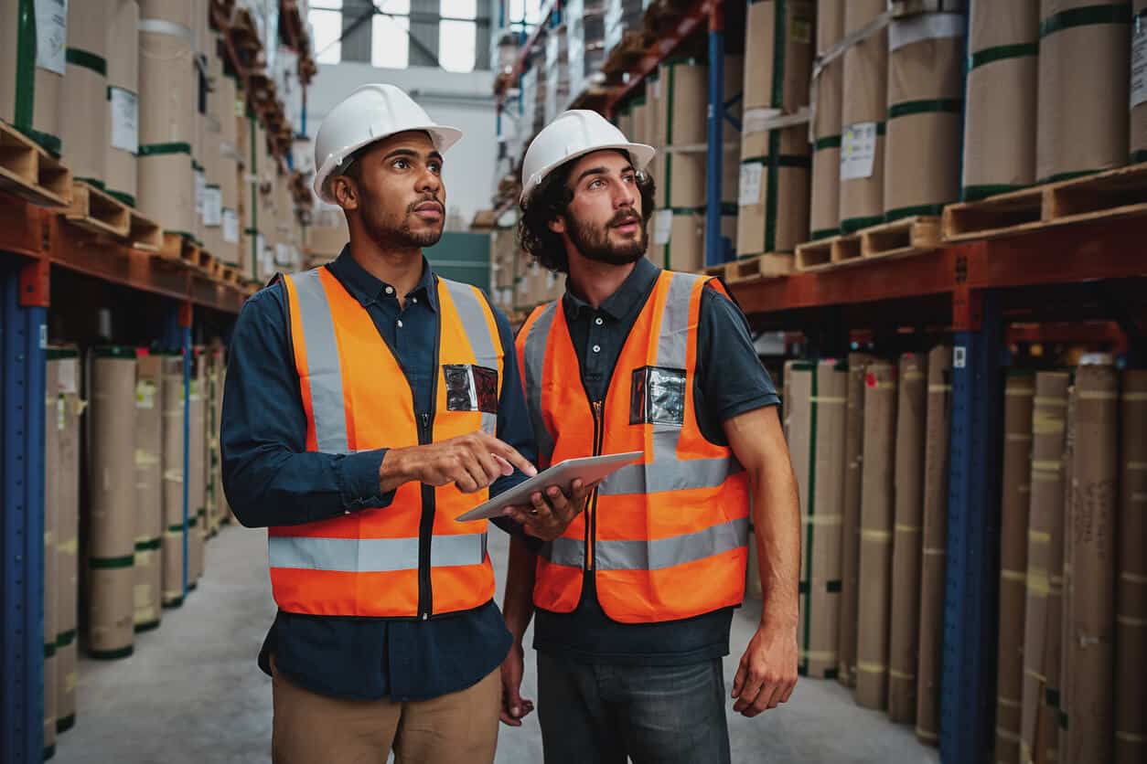 Two warehouse workers looking confused