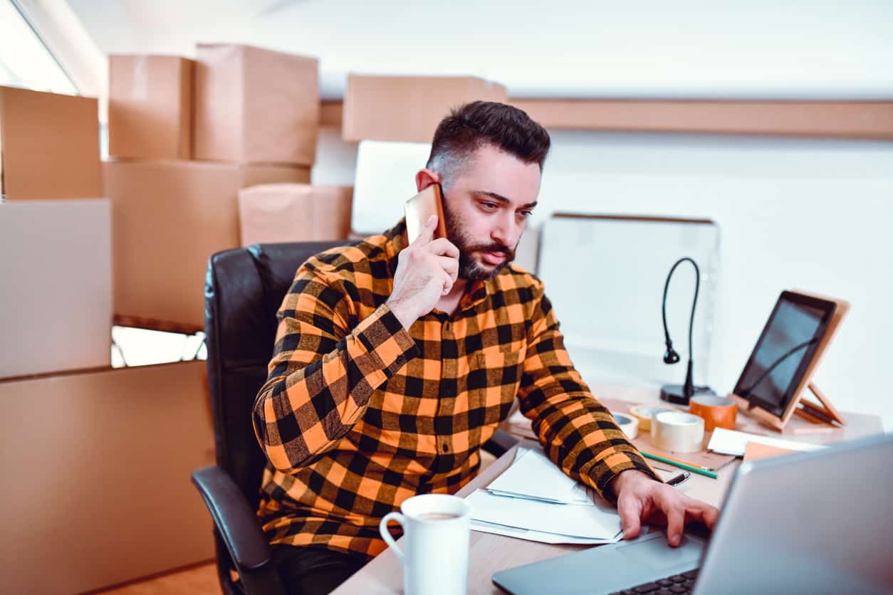 Male Delivery Office Worker Informing Contact About Package Arrival Via Telephone