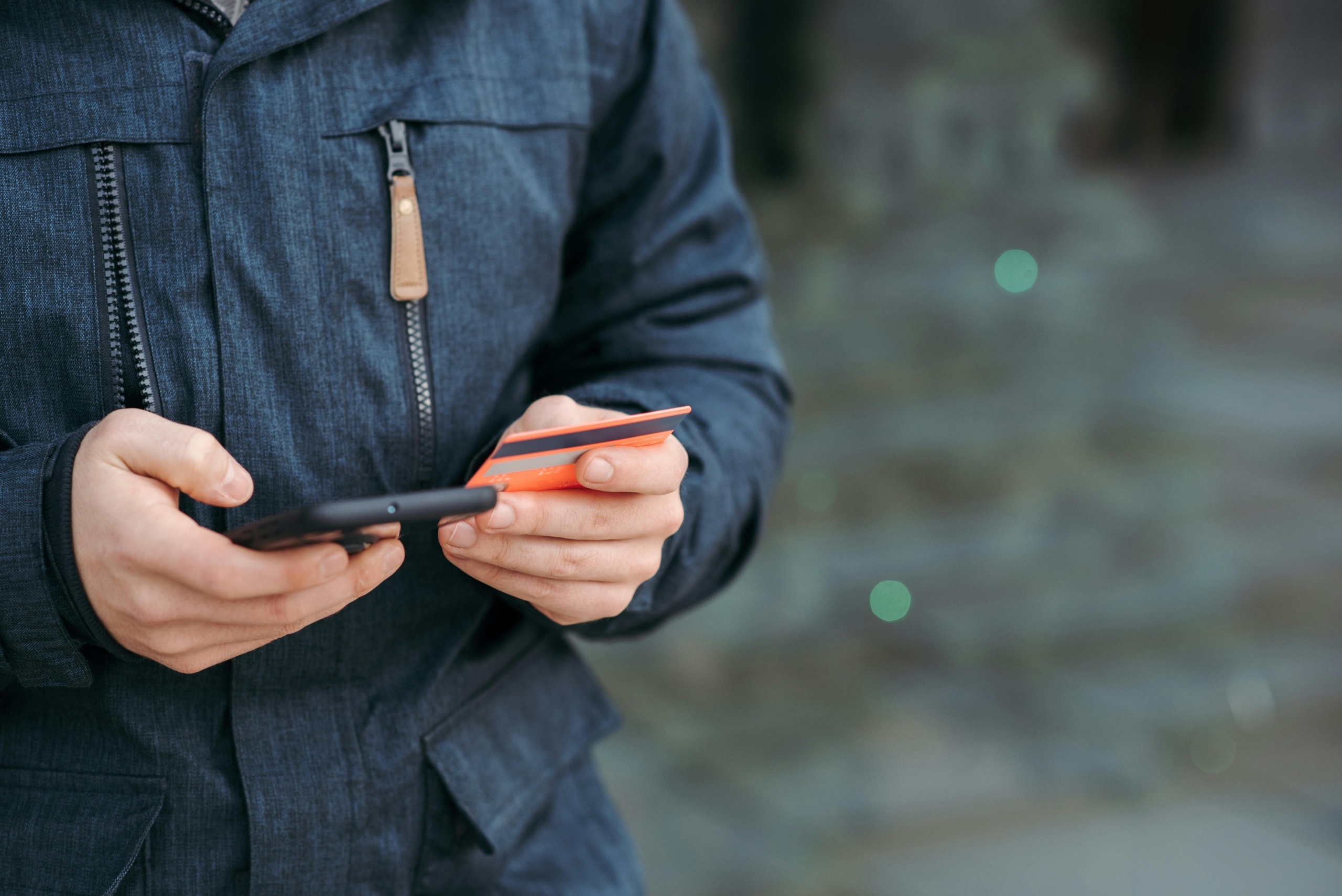 Customer pre-ordering product on phone with credit card in hand.