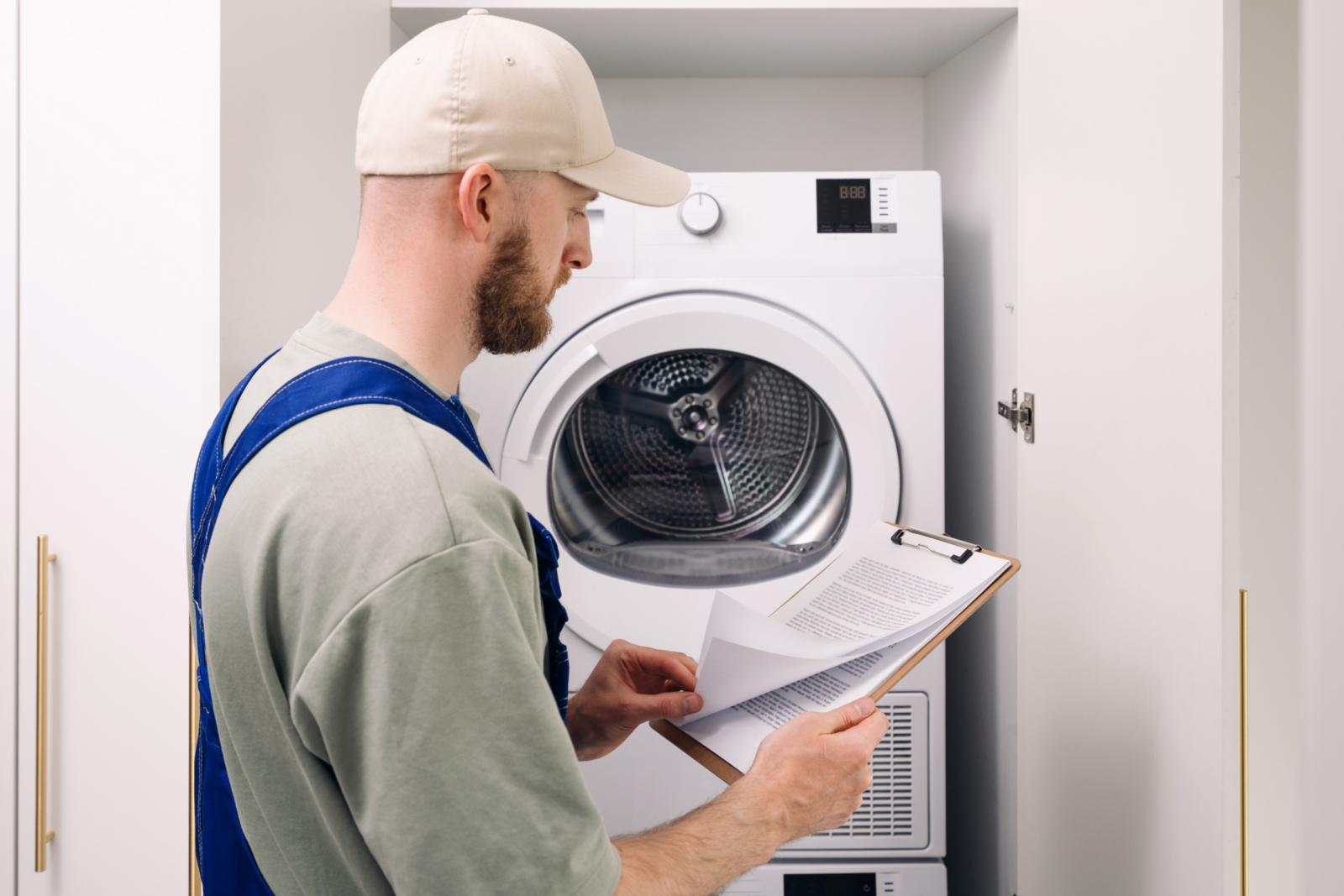 Appliance returns management software in use: technician inspecting a returned large appliance in a repair depot
