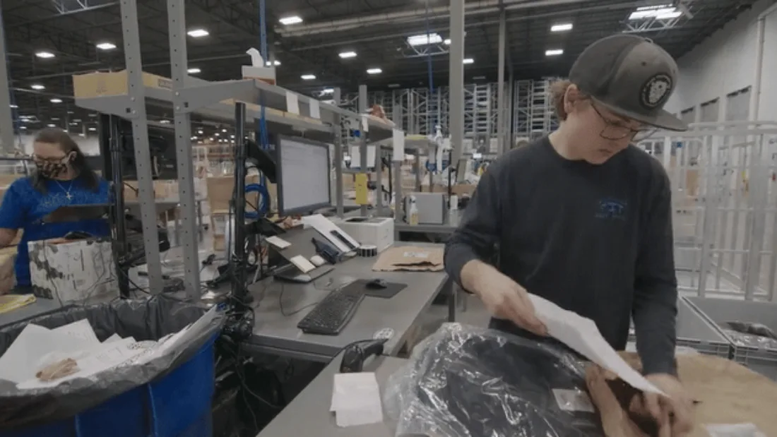 Warehouse employees working through product returns at a bench
