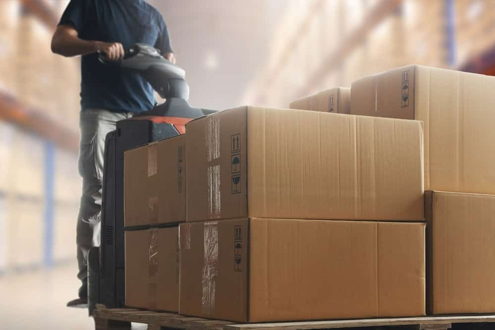 A man moving boxes in a warehouse